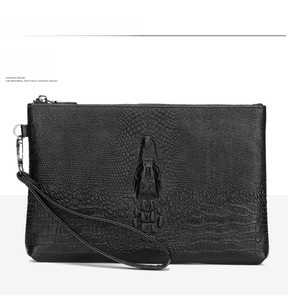 Close-up of black crocodile pattern leather clutch with metal zipper and wrist strap
