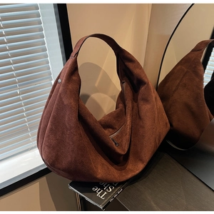 Macro shot of large dark brown suede hobo tote bag with soft texture and zip closure