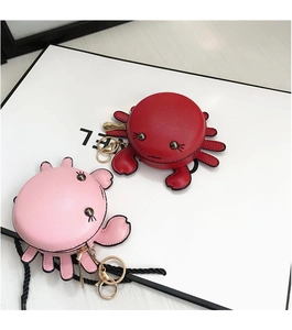 Détail de porte-monnaie crabe rouge et rose avec rivets métalliques et porte-clés doré