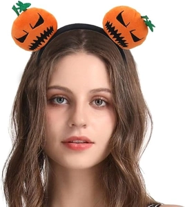 Detail view of funny Halloween pumpkin headband with knitted orange plush decorations on model
