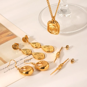 Irregular spiral pendant necklace and textured hoop earrings set in polished gold finish