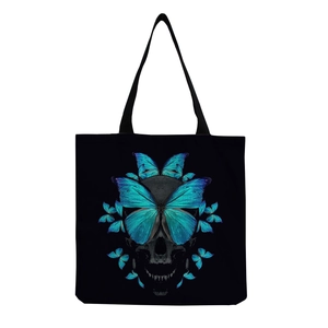 Detailed close-up of vibrant blue butterfly and skull print on a black canvas tote bag