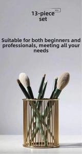 Close-up of 13-piece makeup brush set with dark green handles and gold storage tube
