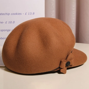 Detail of wool newsboy cap featuring a side bow with a subtle black rhinestone accent