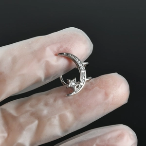 Detail of silver crescent moon and star ear cuff with sparkling zircon inlay design