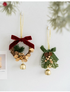 Close-up of Christmas ornaments with velvet bows, golden bells, and natural pine cones