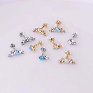 Flat lay of surgical steel labret studs with opal and zircon gemstones in gold and silver
