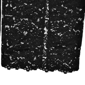 Detailed close-up of intricate black lace fabric featuring elegant floral hollow patterns