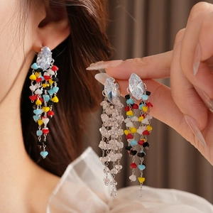 Detail showing long tassel earrings with clear crystals and multi-colored beads
