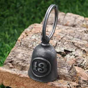 Macro shot of vintage metal guardian bell with number 13 on a rustic wood base