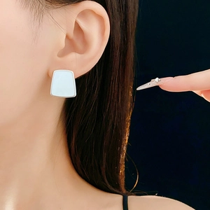 Gros plan de boucles d'oreilles trapèzes géométriques en résine sur cadre en argent