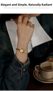 Detail of a minimalist gold watch with a delicate metal mesh strap on a woman wrist