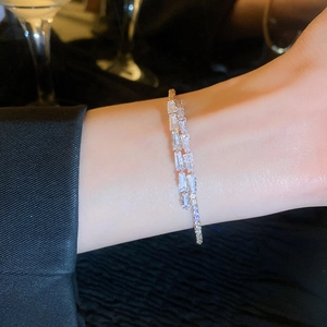 Vue détaillée du bracelet double rangée en zircon doré sur poignet avec éclairage chic