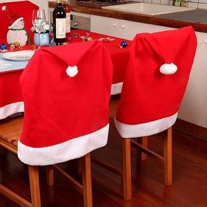 Classic red Christmas hat chair covers with white pom poms for festive dining table decor
