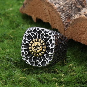 Macro shot of two-tone floral totem ring with hammered texture on natural wood background