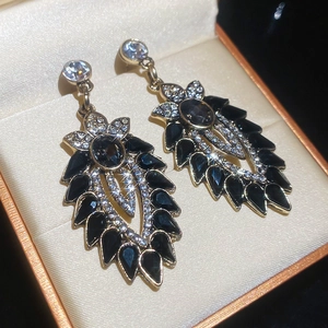 Dettaglio di orecchini vintage con smalto nero e micro-cristalli scintillanti
