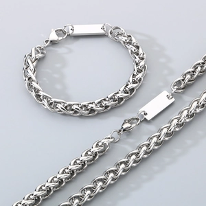 Makroaufnahme von silberfarbenem geflochtenem Edelstahl-Halsketten und Armband Set