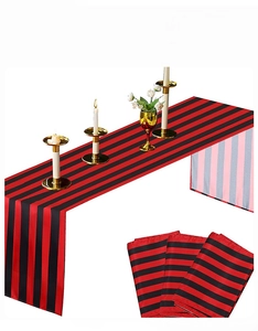Detail of red and black striped table runner with matching napkins and gold accents