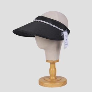 Dettaglio cappello parasole nero a tesa larga con perle decorative e protezione UV attiva