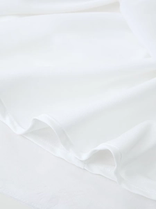 Close-up of white textile fabric texture with detailed stitching and soft draping