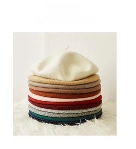 Vertical stack of stylish wool beret hats in various colors with classic top stem detail