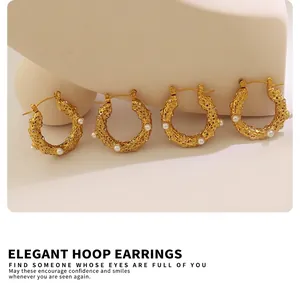 Détail de boucles d'oreilles dorées en forme de U martelé avec perles et zircons