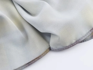 Vue détaillée de la texture du tissu à carreaux gris avec couture à double aiguille