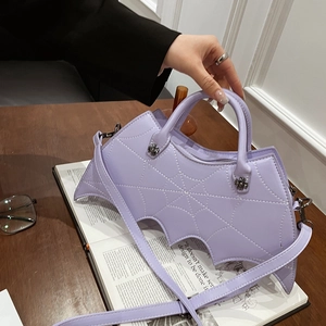 Detail of purple bat wing handbag with silver cross hardware and long shoulder strap