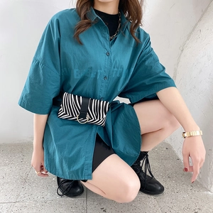 Women's teal short sleeve shirt with animal print belt bag and street style fashion outfit