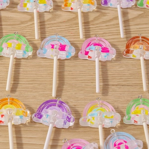 Colorful resin rainbow lollipop pendants with metal rings on light wood surface
