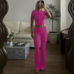 Dettaglio del set pantaloni a zampa a vita alta e top corto color magenta