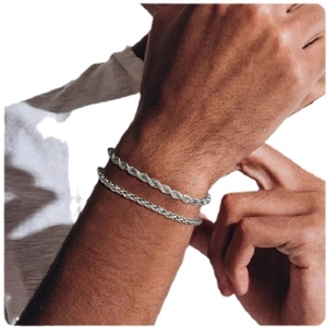 Dual silver titanium steel cable chain bracelets layered on male wrist with white background