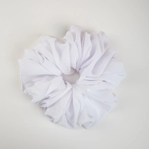 Detailed close-up of a white pleated chiffon hair scrunchie with soft elastic texture