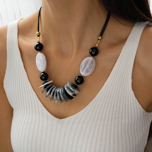 Detailed view of women's vintage necklace with acrylic oval beads and layered pendant