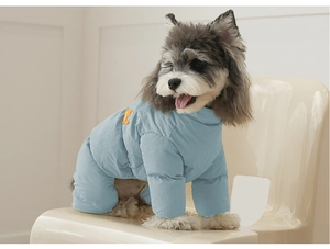 Detail eines hellblauen Winter-Hundeoveralls mit orangefarbenem Bärenaufnäher für kleine Hunde
