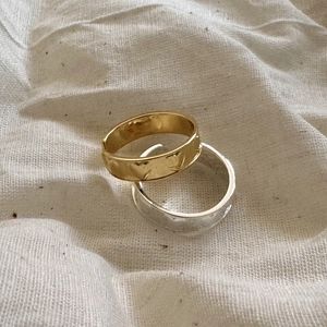 Detailed view of gold and silver S925 rings with handmade hammered texture on fabric