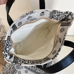 Detail of spacious interior with zipper closure and black paisley canvas tote bag