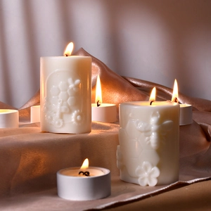 Dettaglio di candele con rilievo a nido d'ape e api su sfondo di seta elegante