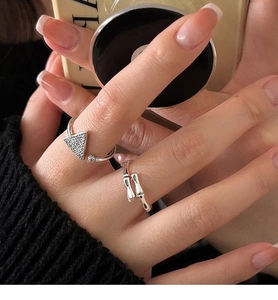Primer plano de anillos de plata S925 con diseño de bambú y triángulo puestos en dedos