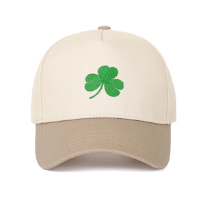 Close-up of green shamrock embroidery on two-tone khaki and beige baseball cap