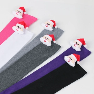 Close-up of colorful striped Christmas socks featuring 3D plush Santa Claus decorations