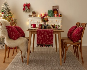 Detail of red Christmas table runner and pillows with gold bells and festive tassels