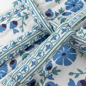 Détail d'un manteau en coton à imprimé floral bleu avec nœud de ceinture à la taille