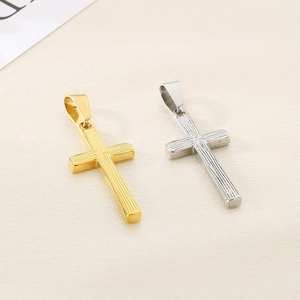 Macro detail of gold and silver cross pendants with vertical stripe texture and metal finish