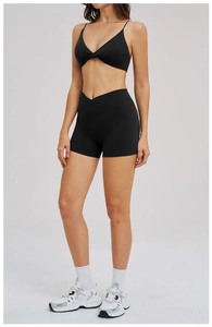 Detail of cross-over high waistband and knotted bra design on black yoga set