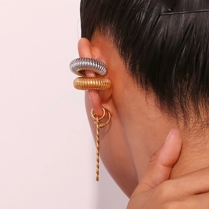 Close-up of stacked gold and silver textured ear cuffs and twisted earring on model ear