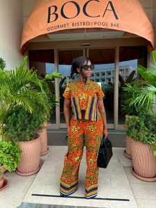 Detail of African print two-piece set with V-neck top and wide-leg trousers in orange