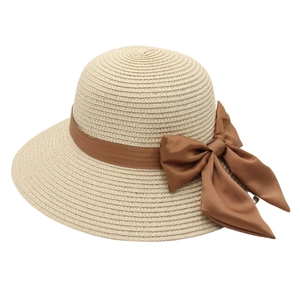 Elegant wide brim straw sun hat with large brown ribbon bow for beach vacations