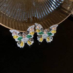 Macro detail of butterfly crystal drop earrings featuring colorful stones and fine metalwork