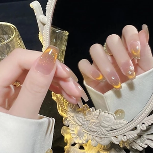 Lange Trapez-Kunstnägel mit bernsteinfarbenem Katzenaugeneffekt und Goldglitzer